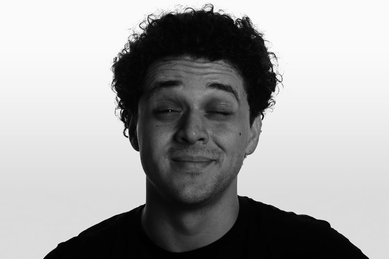 Retrato em preto e branco do fotógrafo piscando um olho, em tom descontraído
